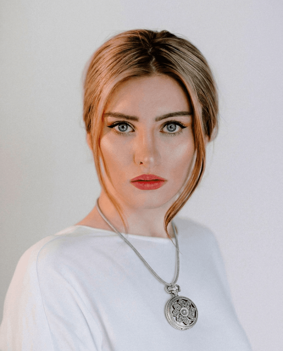 Blonde Woman Wearing Ornate Pendant example 7
